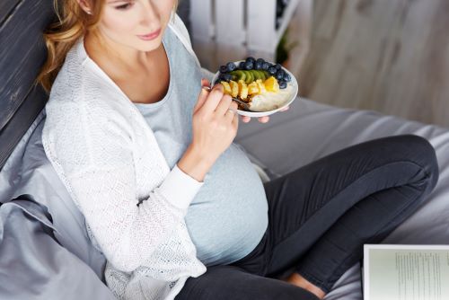 Mujer embarazada comiendo fruta